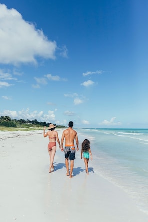 In Strandnähe, weißer Sandstrand, Liegestühle, Sonnenschirme