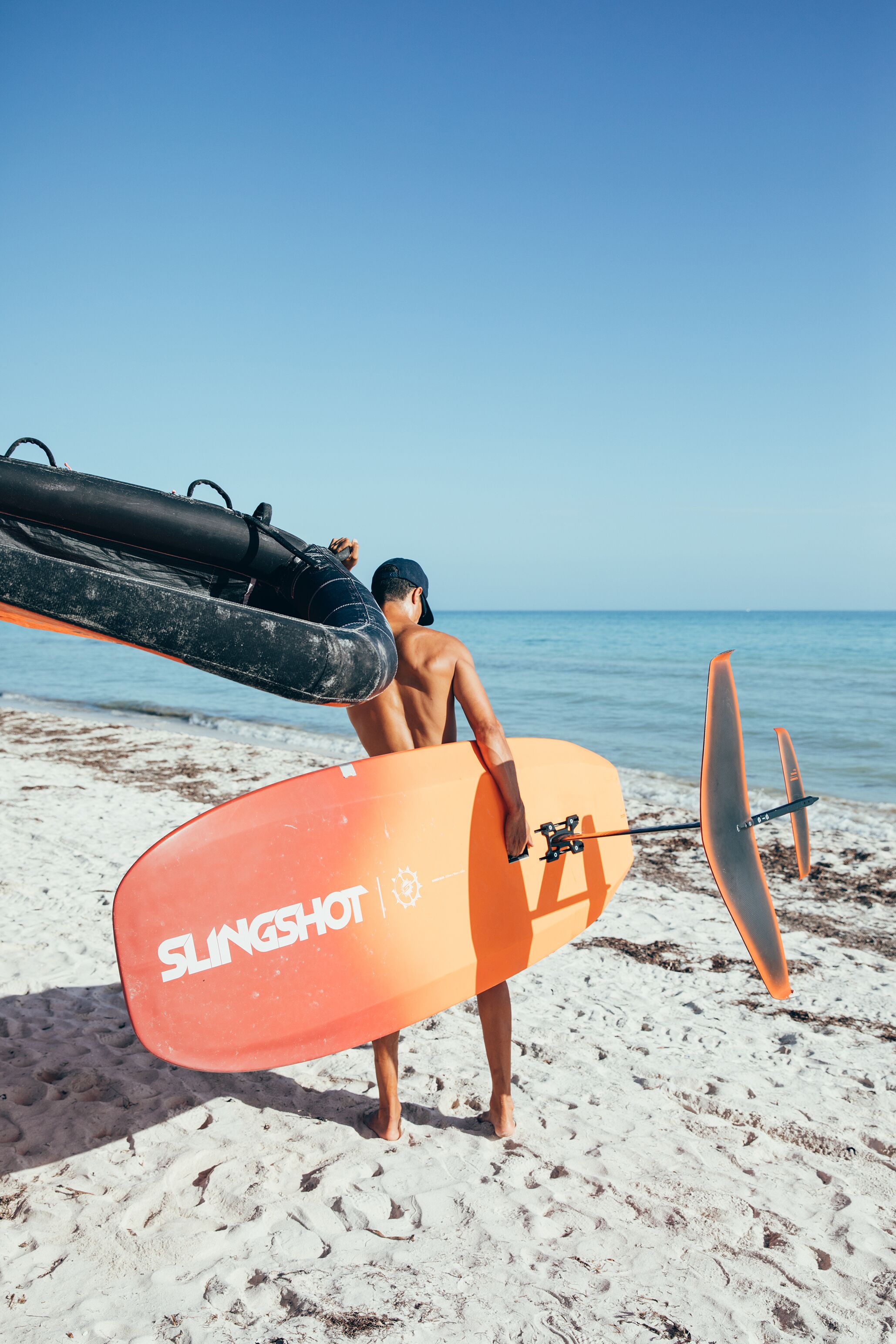 En strandscene med en person, der holder et surfbræt og en redningskrans.