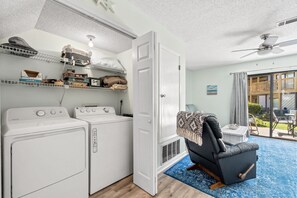 Convenient laundry facilities and a door leading to a balcony.