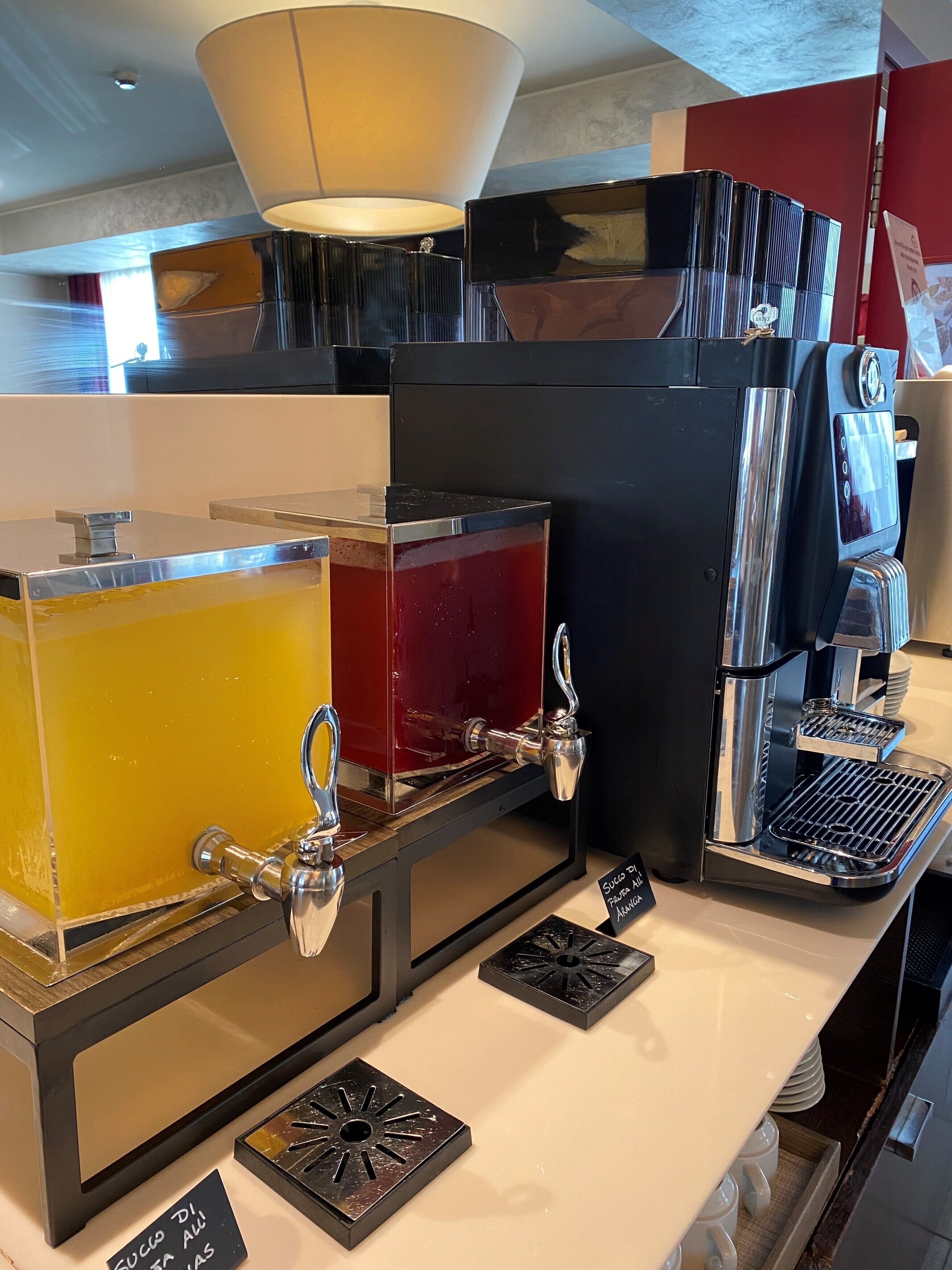 Eine Kaffeemaschine mit mehreren Ausgabesystemen, einer Kaffeemühle und einem Milchaufschäumer.