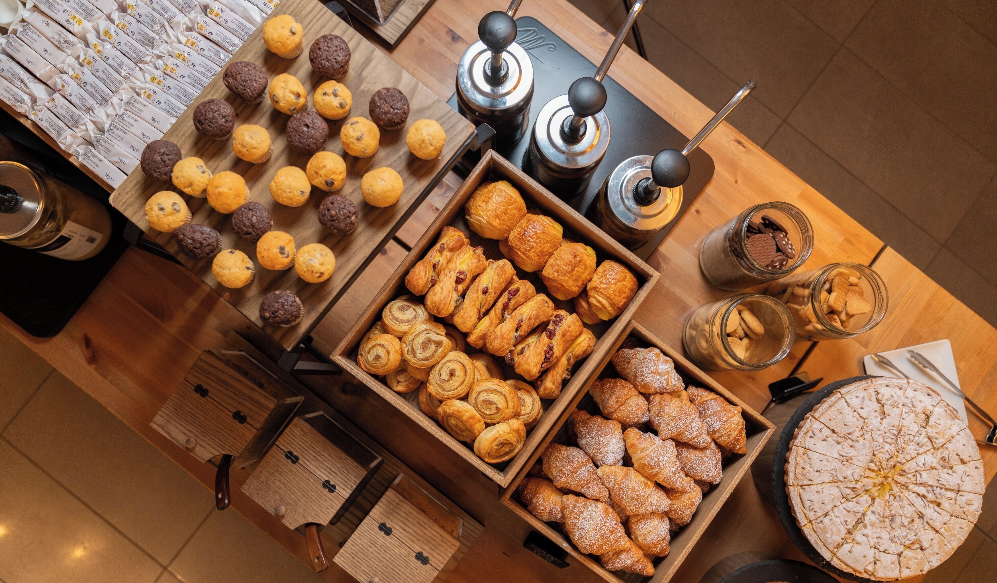 A variety of pastries and baked goods displayed on a wooden table.