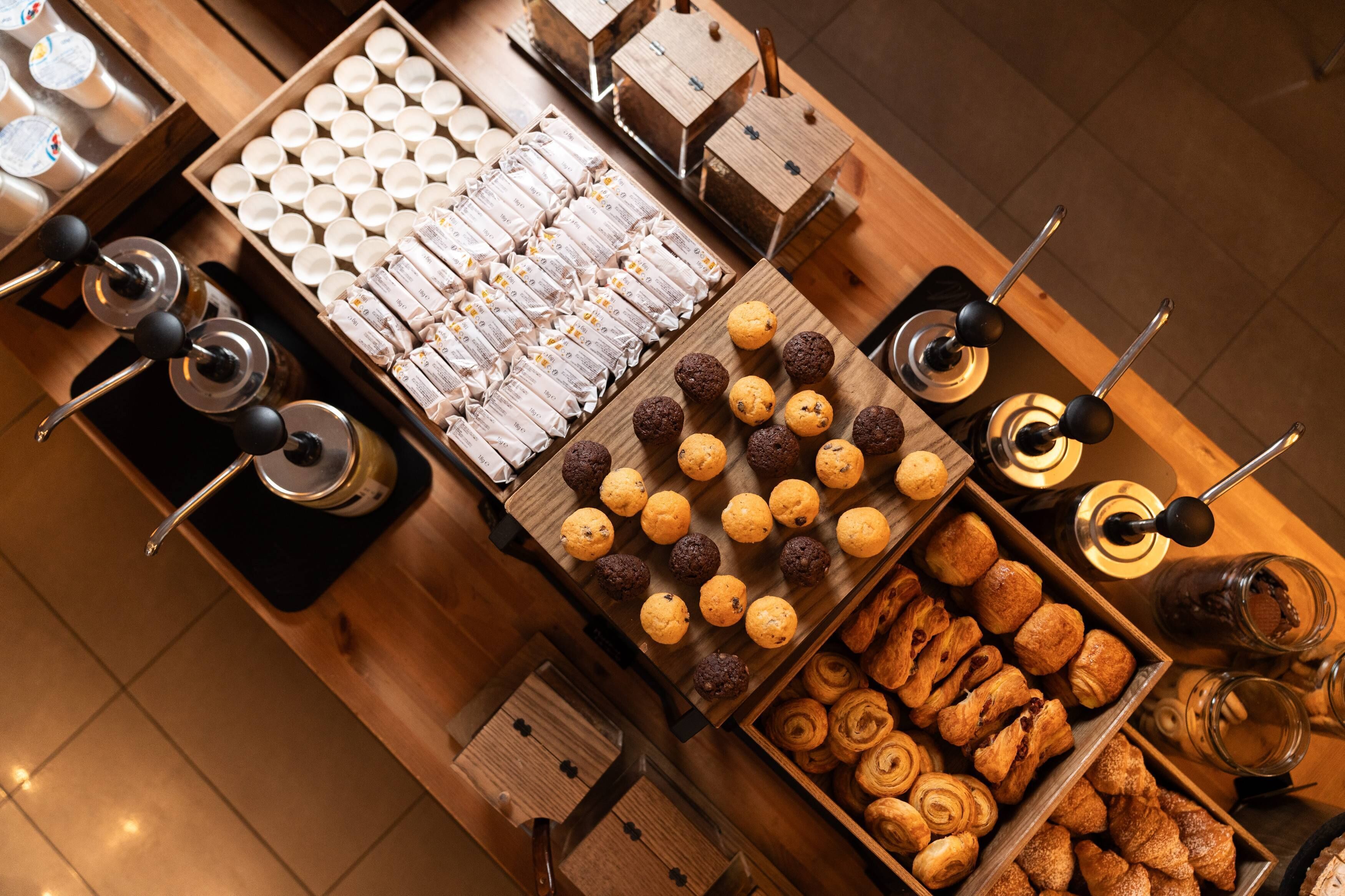 A variety of pastries and baked goods displayed on wooden trays and boxes.