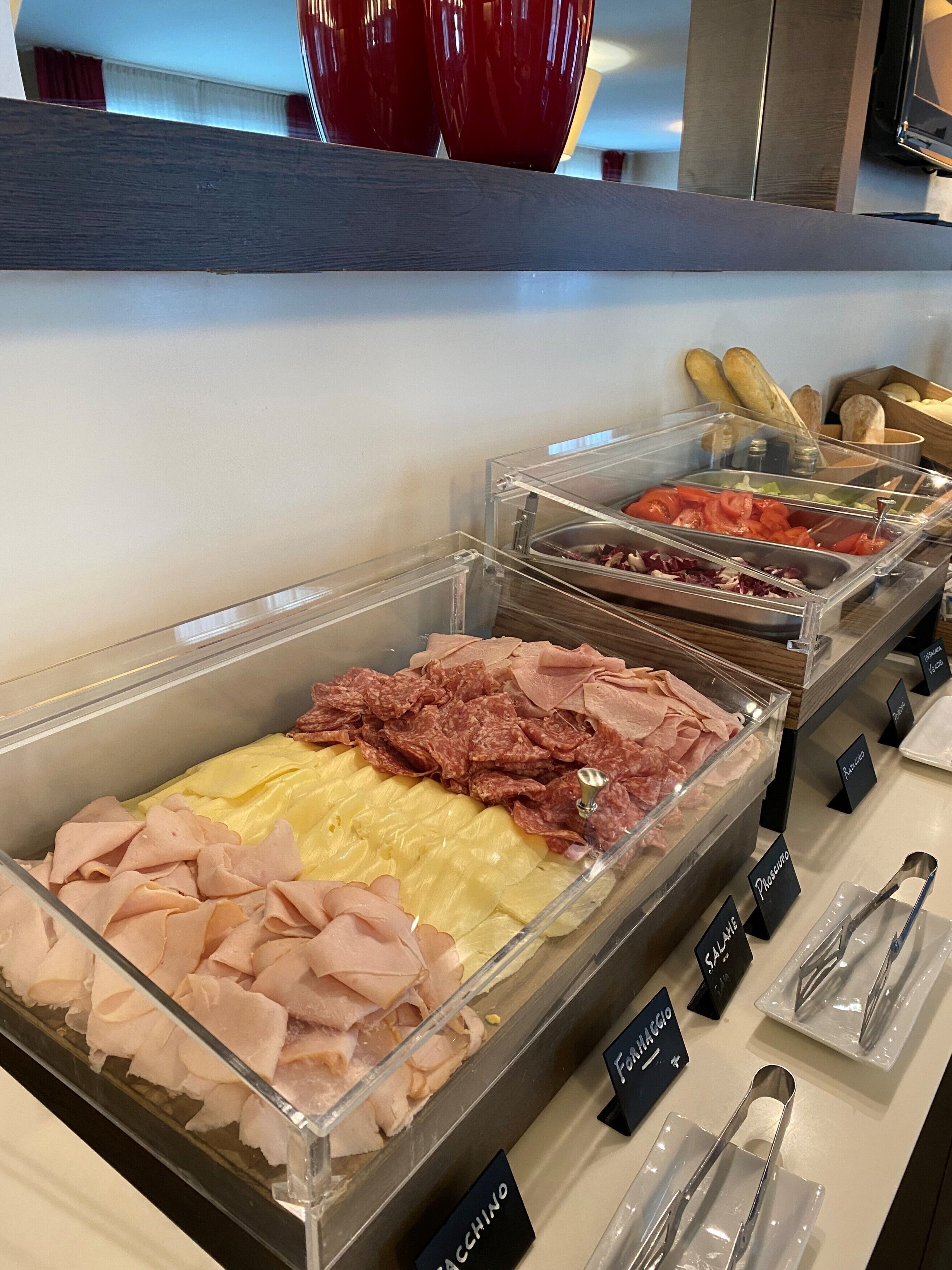 A buffet with various meat options including ham, salami, and prosciutto.