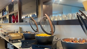 Montaje tipo buffet con varias estaciones de servicio, que incluyen una variedad de platos y cubiertos.