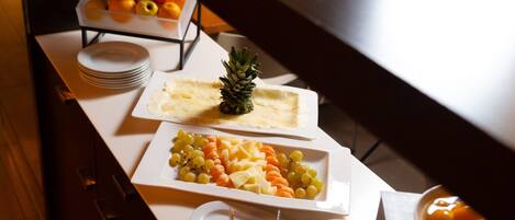 A buffet table with various fruits and cheeses.