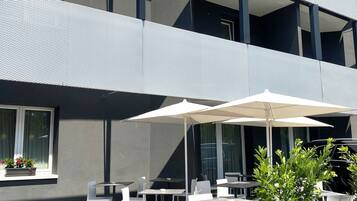 A modern building with outdoor seating and a potted plant.