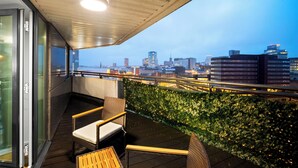 Ein Balkon mit Blick auf eine städtische Skyline im Abendlicht.