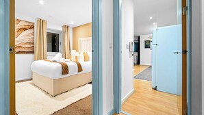 Ein modernes Hotelzimmer mit einem großen Bett, einem flauschigen Teppich und einer Wand mit Holzverkleidung.