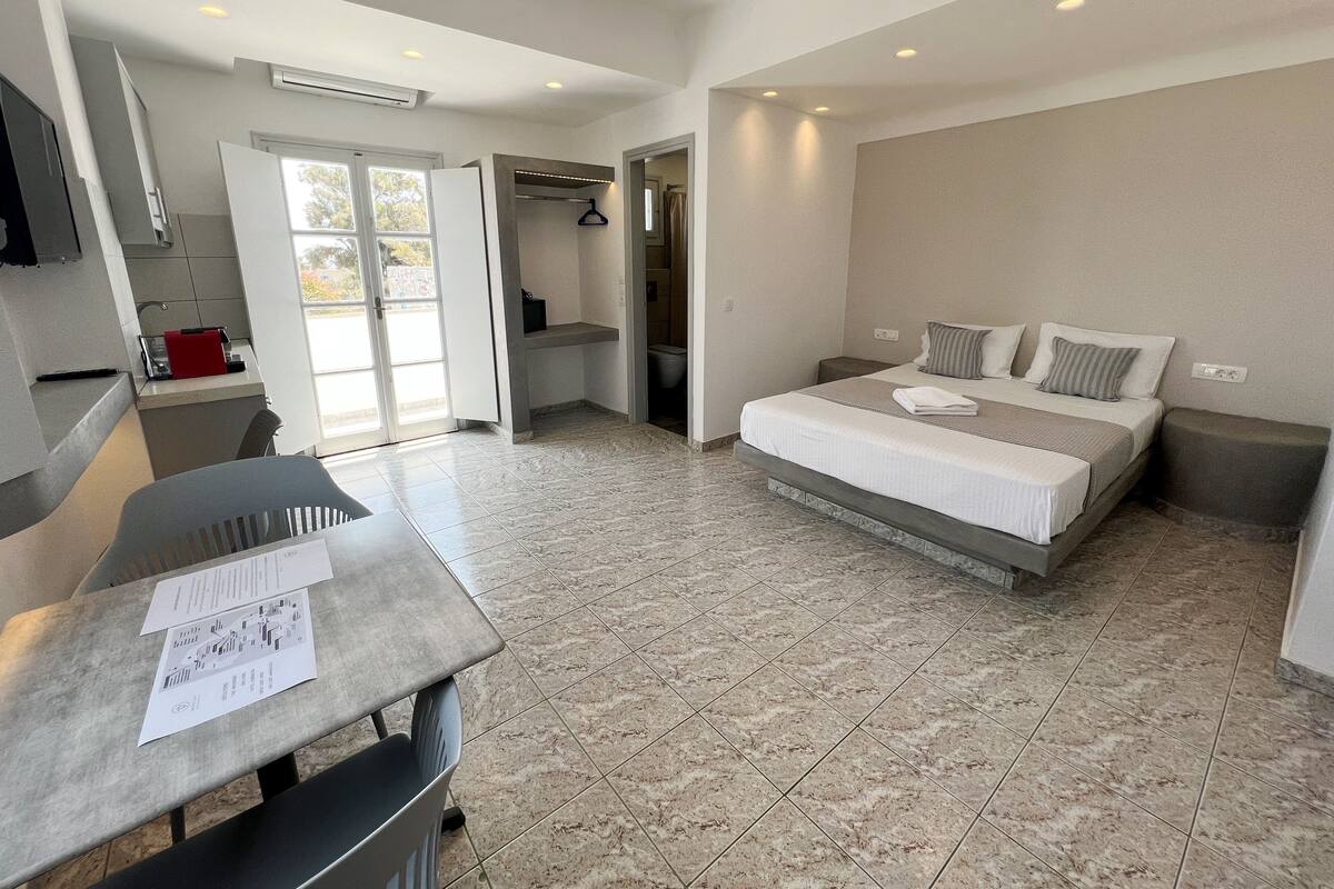 Une chambre d’hôtel moderne équipée d’un lit, d’un bureau et d’une kitchenette.