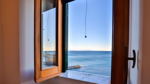 A room with a window overlooking a beach. - The Window to the sky (Amalfi)