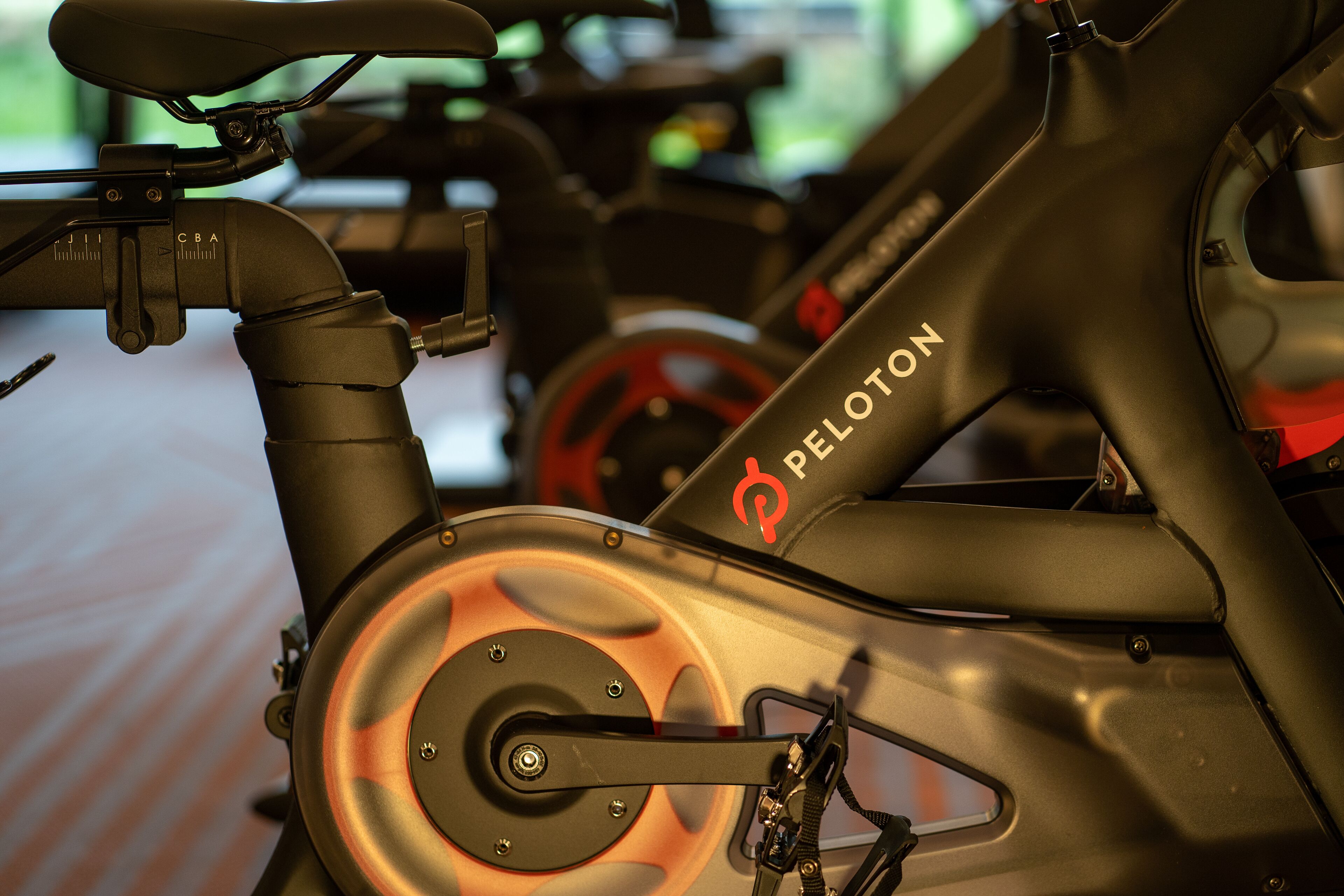 Primer pla d'una bicicleta estació Peloton amb estructura negra i detalls vermells.