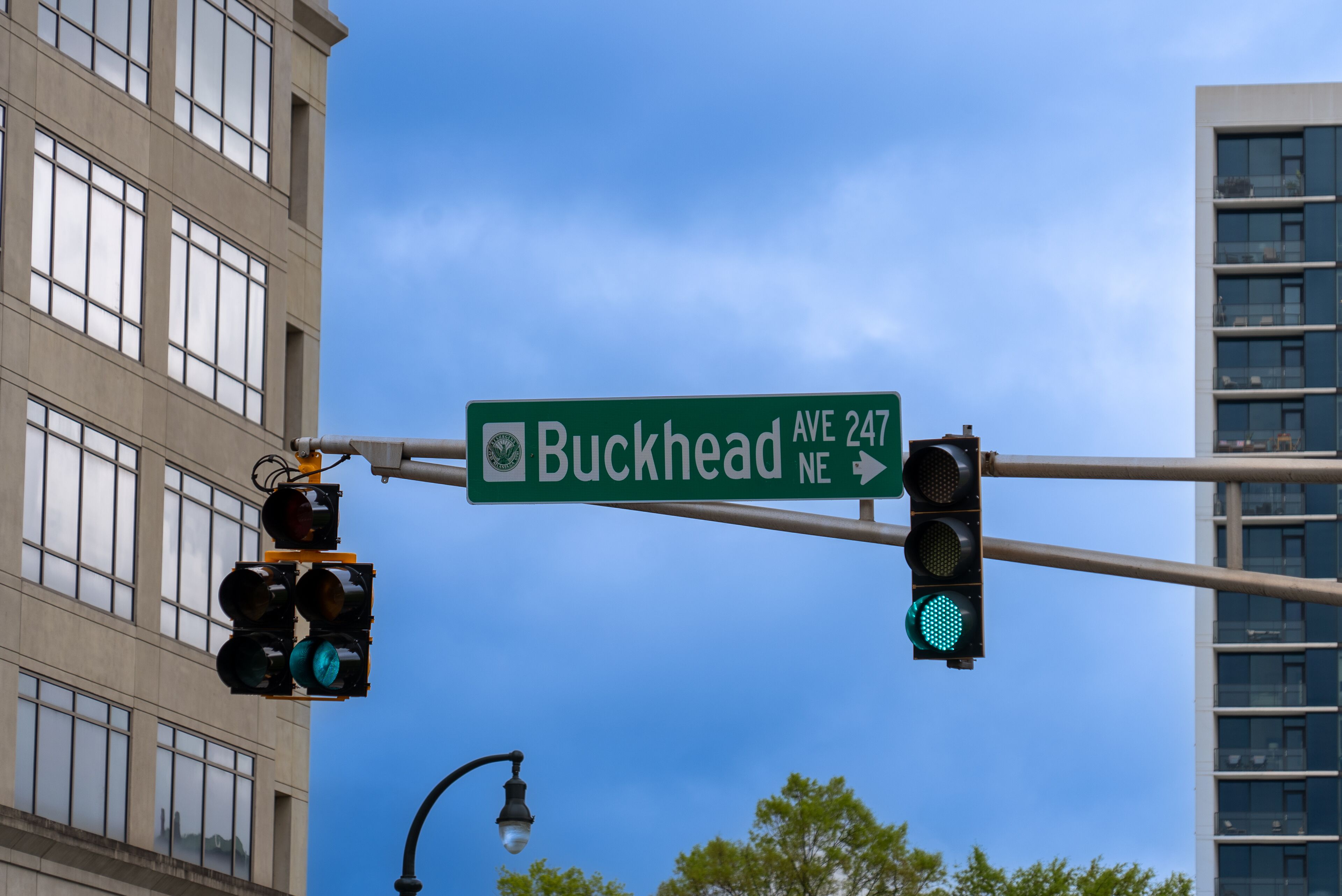A street sign for Buckhead Ave NE with a traffic light.