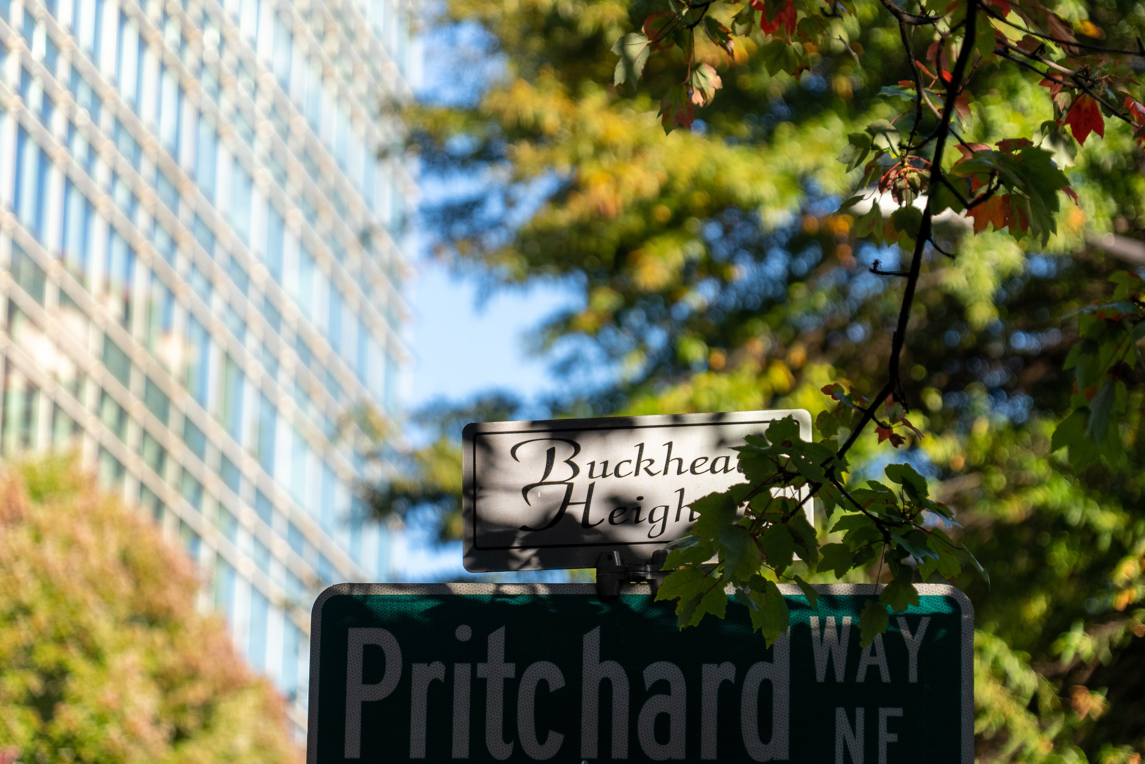 A street sign for 'Buckhead Heights' and 'Pritchard Way NE' with a building in the background.