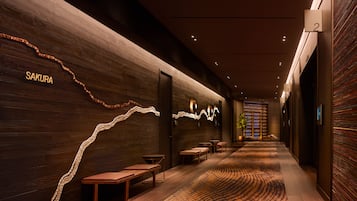Experience the sleek, contemporary design of our hotel's minimalist corridor, featuring a unique light installation and stylish signage.