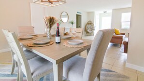 Comedor con una mesa de madera dispuesta para cuatro personas, rodeada de sillas acolchadas.