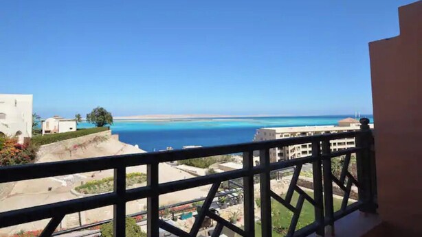 Een balkon met uitzicht op de zee en gebouwen.