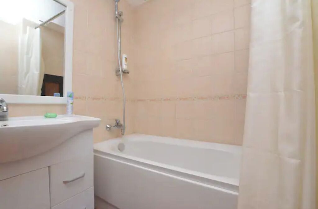 Een badkamer met een bad, een wastafel en een spiegel.