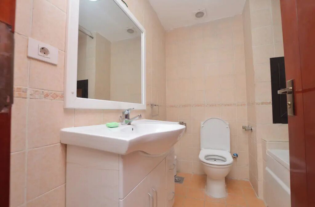 Un bagno piccolo con un lavandino, uno specchio e un water bianchi.