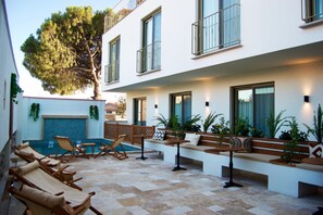 A modern outdoor patio with lounge chairs, a pool, and potted plants. - Boja Küçükköy (Ayvalik)