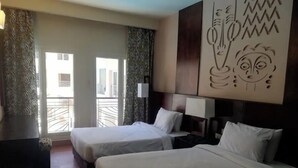 A hotel room with two beds, a large window, and a decorative wall piece. - 2 bedroom & breakfast in The Bosque Hotel Hurghada (Red Sea Governorate)