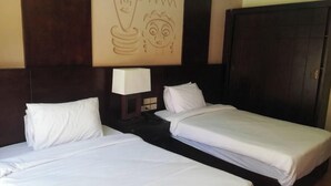 A hotel room with two single beds, a nightstand with a lamp, and a dark wooden wardrobe. - 2 bedroom & breakfast in The Bosque Hotel Hurghada (Red Sea Governorate)
