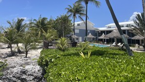 Ett semesterparadis med pool, palmer och en strand.
