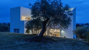 Ein modernes, zweistöckiges Gebäude mit einem großen Baum davor.