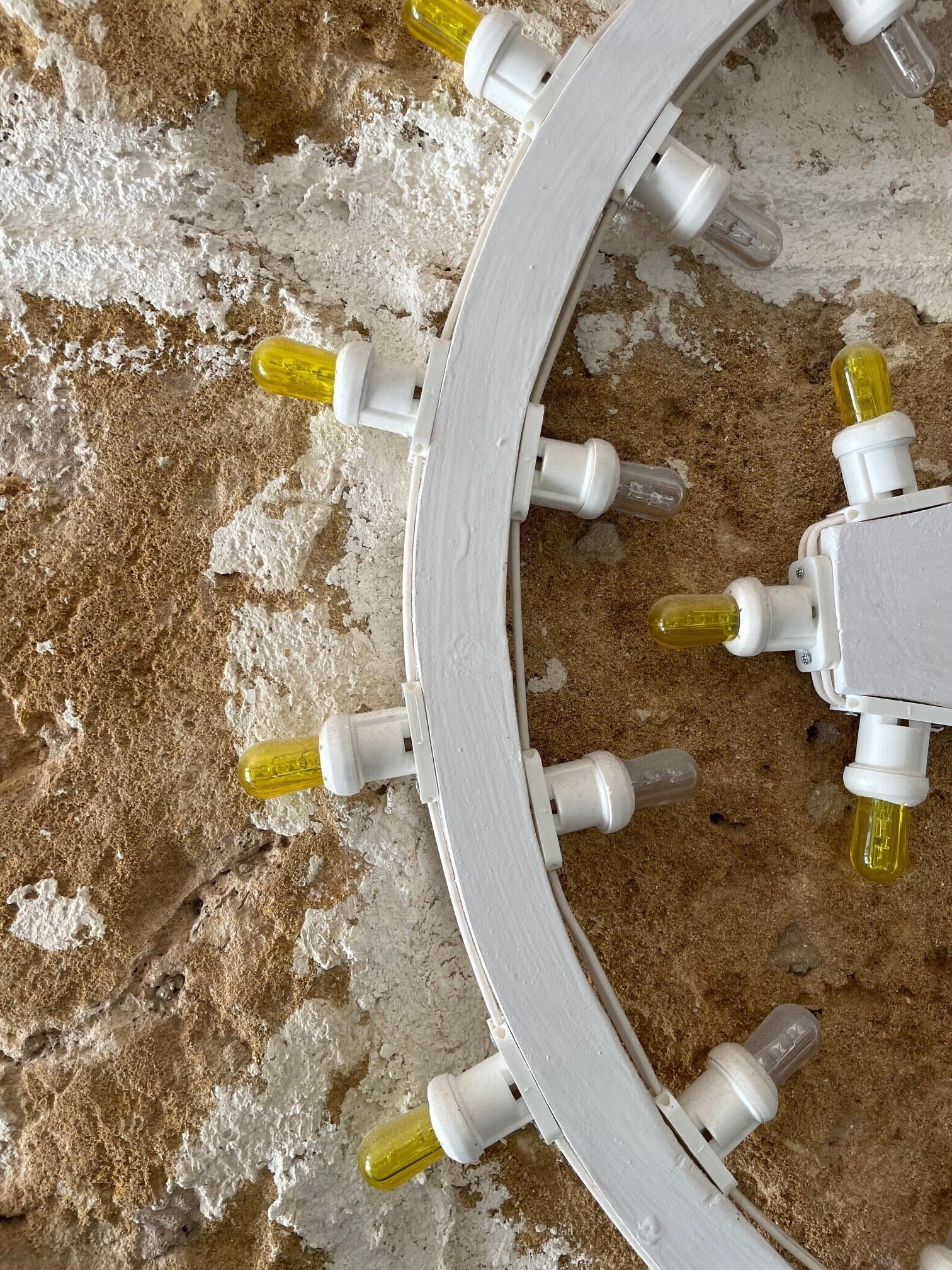 A white circular object with multiple light bulbs attached to it.