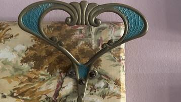 Un maniglia decorativa in metallo su sfondo di tessuto floreale.