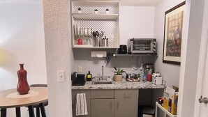 A compact kitchen with a countertop, a sink, a toaster, and a trash bin. -  Homey Work and Play Private Suite in Citrus Park! (Tampa)