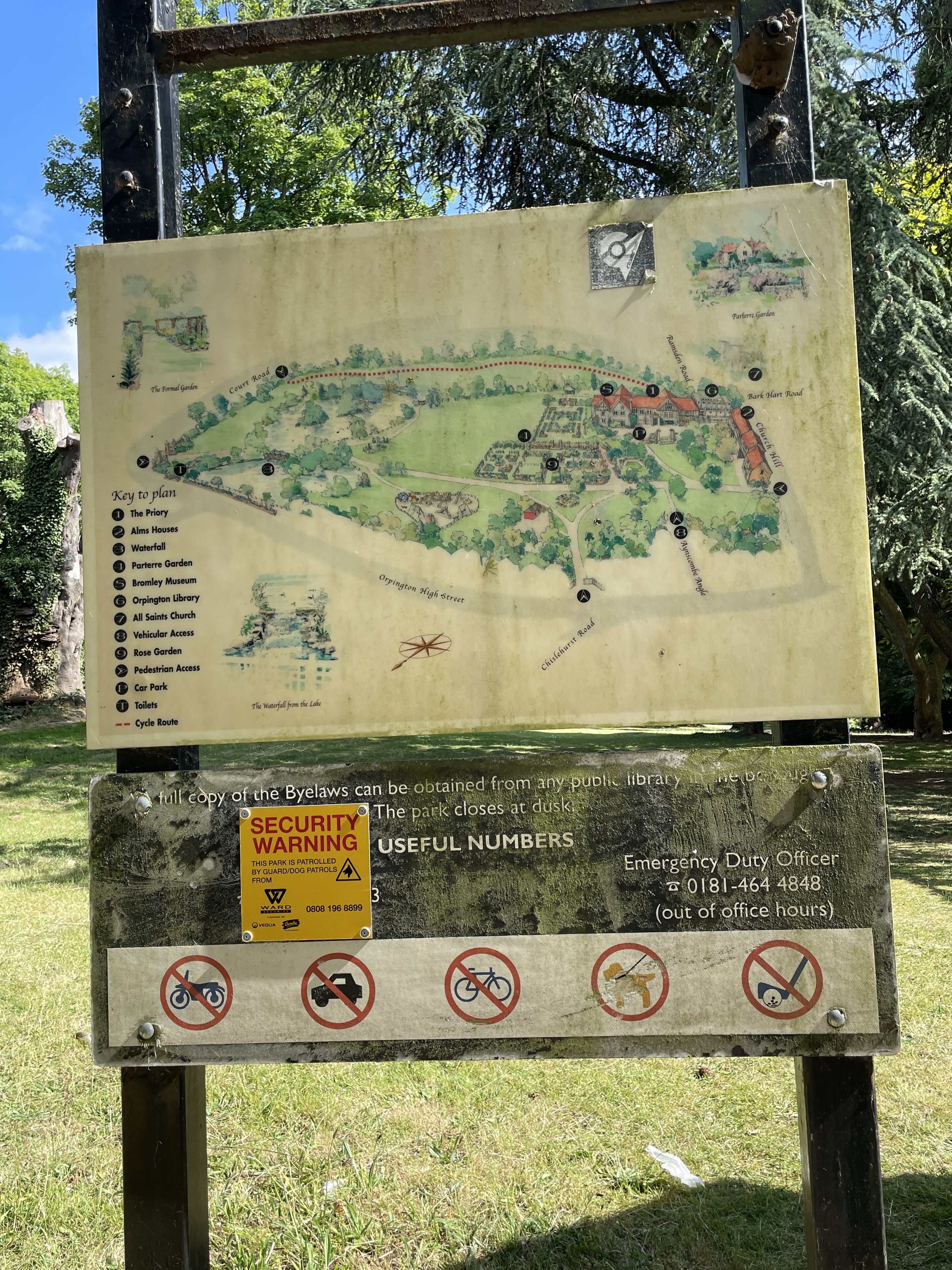 A park map with a security warning and useful numbers sign.