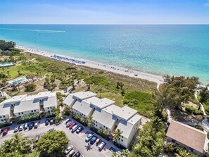 Vista aerea di un hotel sulla costa, con spiaggia, parcheggio e area piscina.
