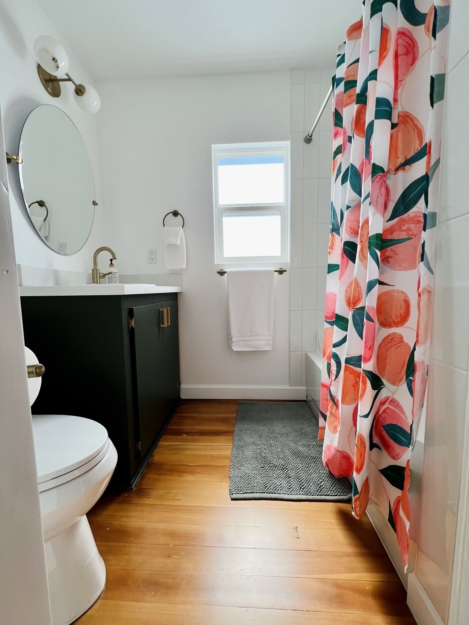 A bathroom with a toilet, sink, mirror, and shower curtain.