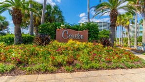 Placa indicando 'Cahibe Resort', rodeada por vegetação exuberante e palmeiras.