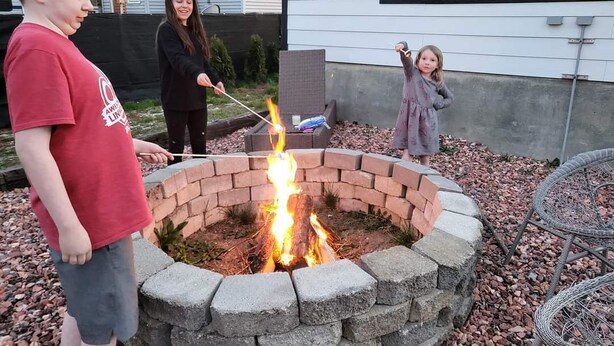 A fire pit in a circular stone structure with a brick border, surrounded by a gravel area. - Midcentury modern home 5min from Riverfront park (Spokane)