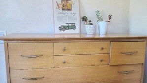 A wooden dresser with multiple drawers and a single hanging cabinet. - Midcentury modern home 5min from Riverfront park (Spokane)