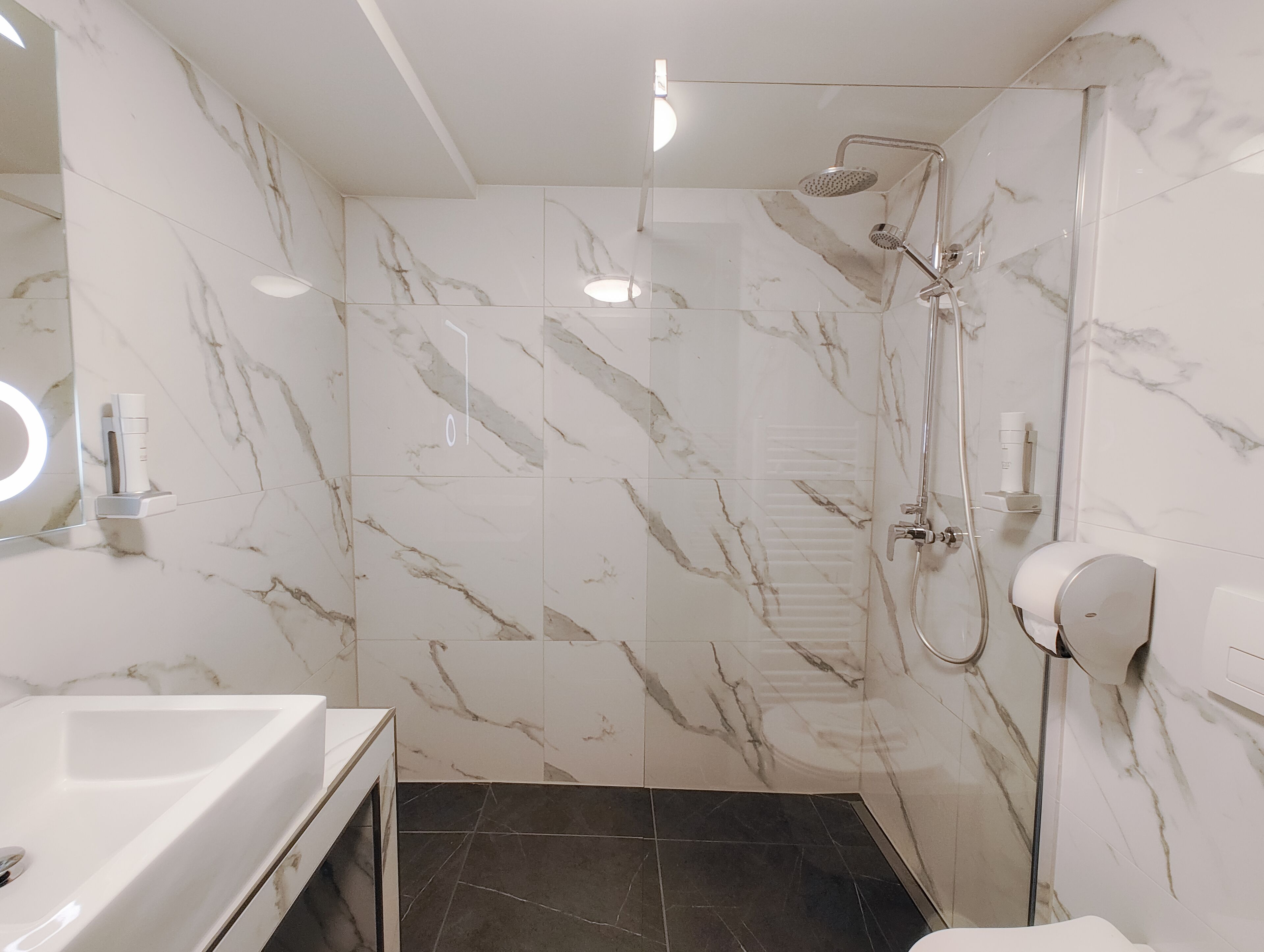 Ein modernes Badezimmer mit Dusche, Waschbecken und Toilette.