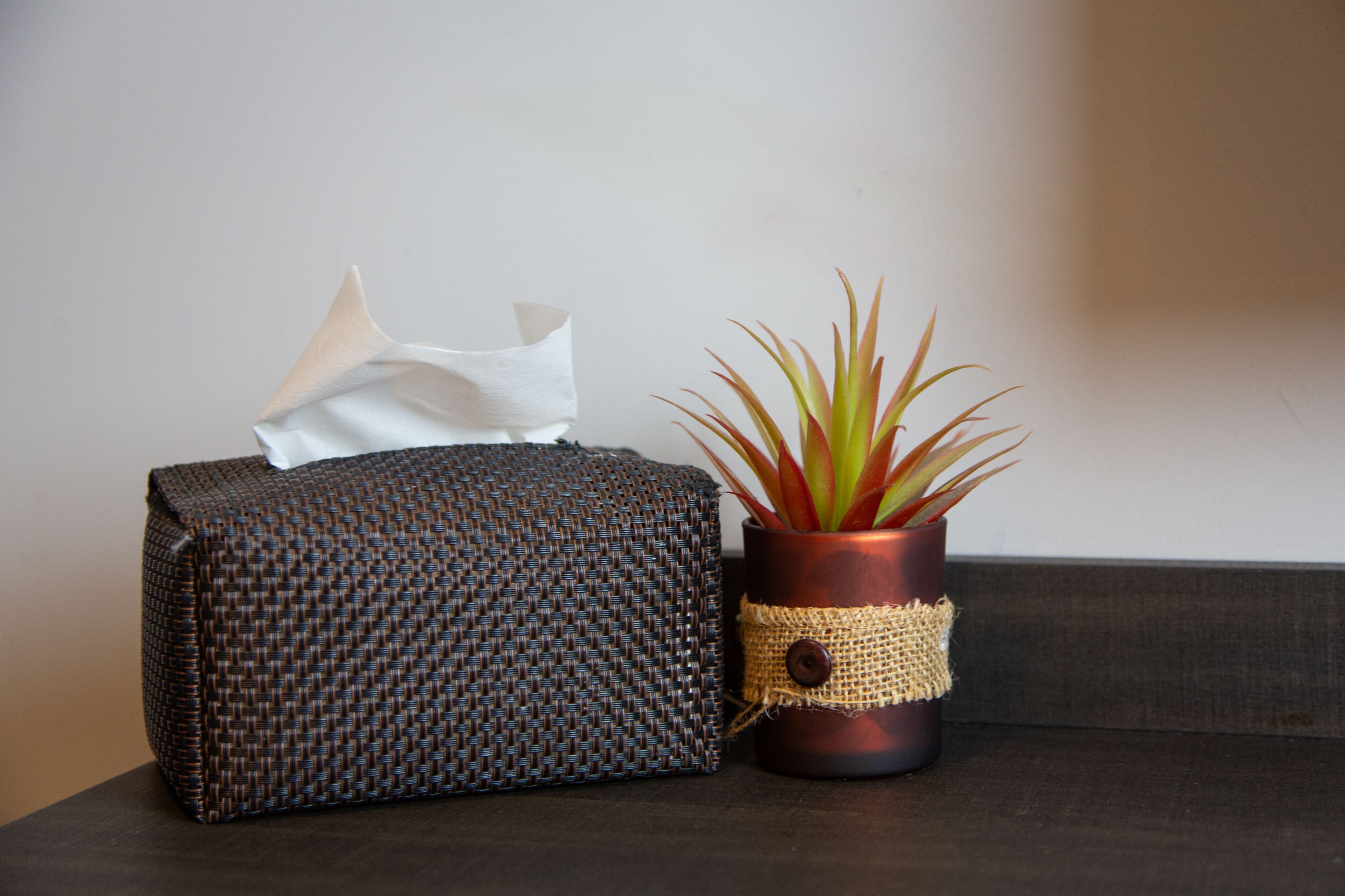 A woven fabric item and a potted plant with a burlap wrap and button.