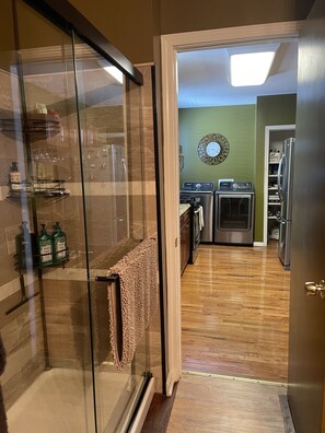 Une cuisine moderne dotée d’une cabine de douche en verre, d’un four encastré et d’un réfrigérateur.