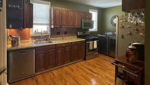 A kitchen with wooden cabinets, a stainless steel refrigerator, a microwave, and a stove. - Minutes from Churchill Downs & Downtown Lou! (Louisville)
