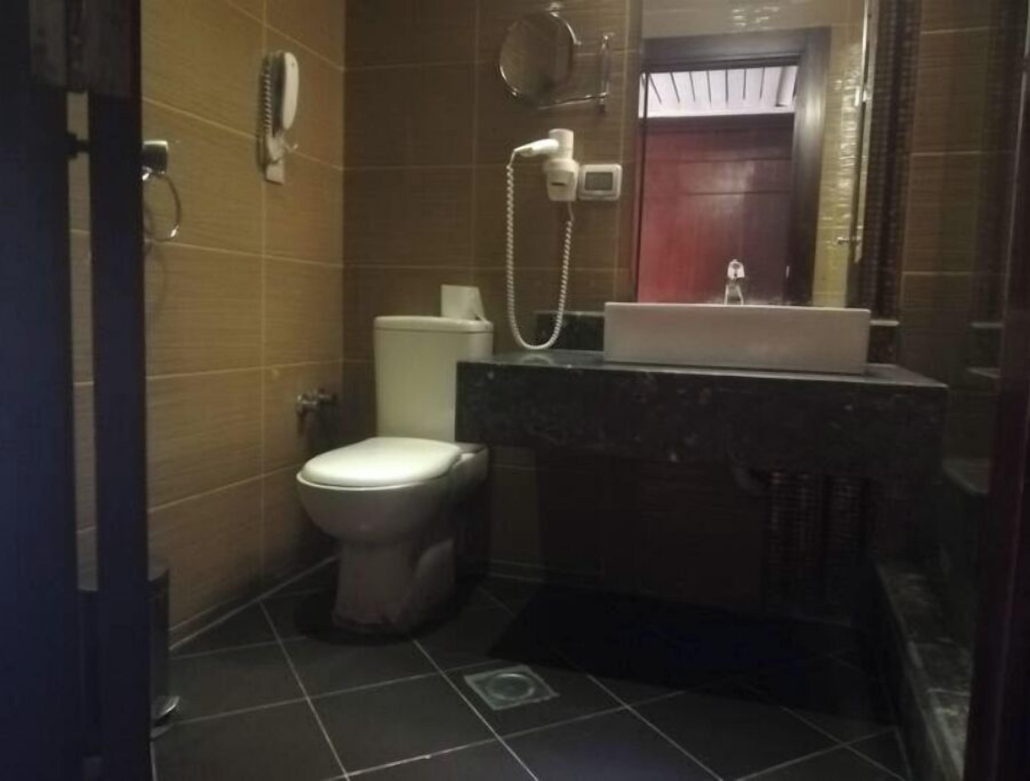 A small bathroom with a toilet, a sink, and a shower.