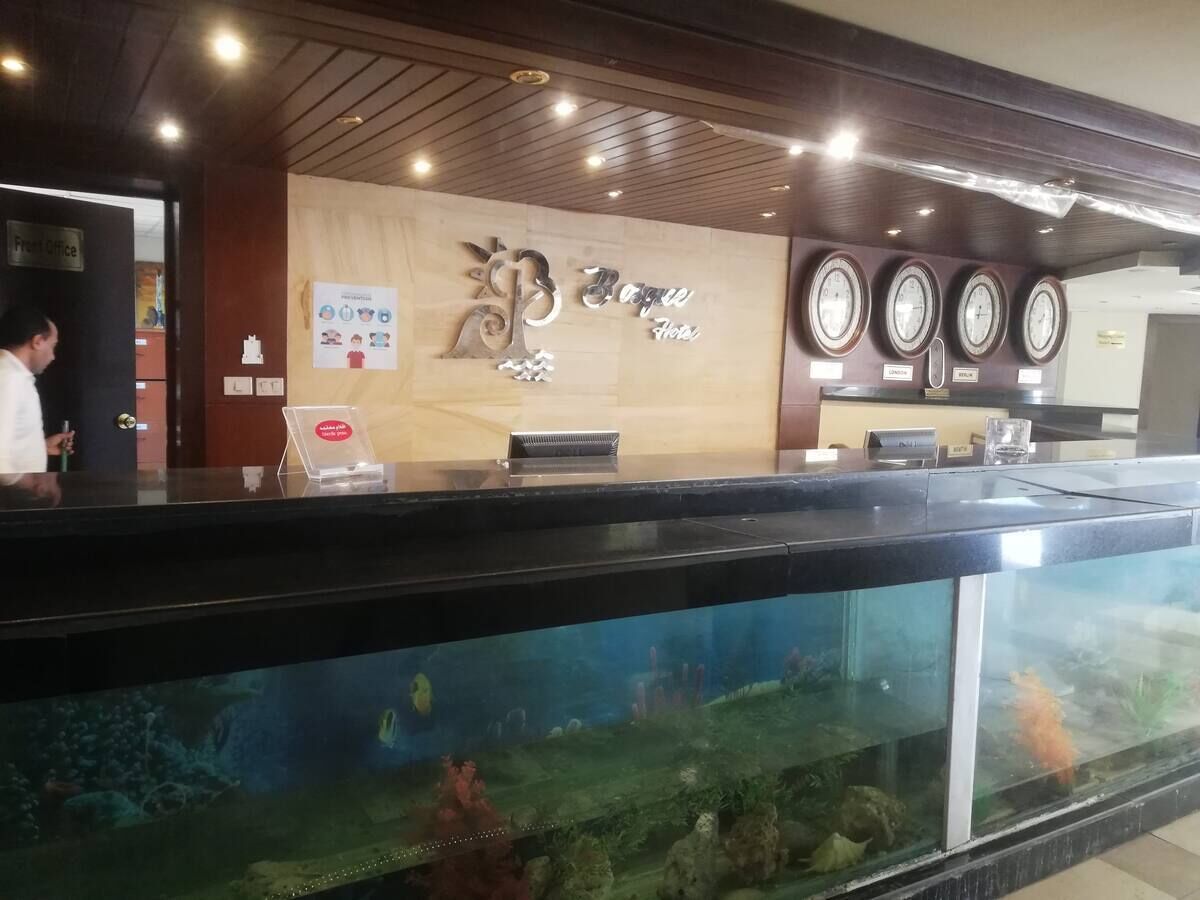Ein Hotelrezeptionstresen mit einem großen Aquarium im Vordergrund.