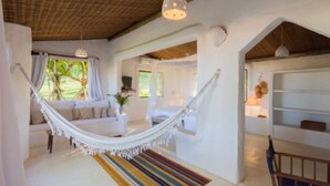 Una habitación amplia con una hamaca, un sofá y un comedor.