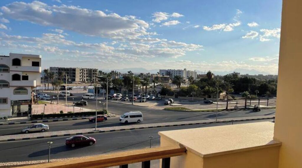 A cityscape with a road, buildings, and a clear sky.