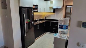 A compact kitchen with a refrigerator, sink, and cabinets. - luxury apartments in aldau heights with two pools 11514 (Hurghada)