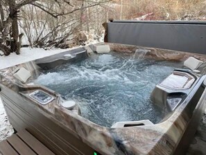 Relax in the outdoor hot tub with a seat and control panel.