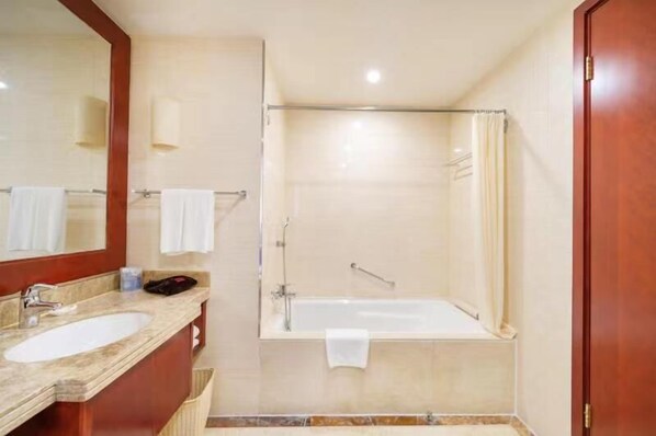 Un baño con lavamanos, espejo y zona de ducha.