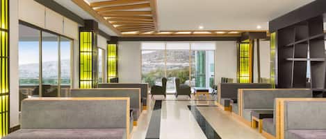 A modern interior with seating areas, large windows, and a view of the outdoors.