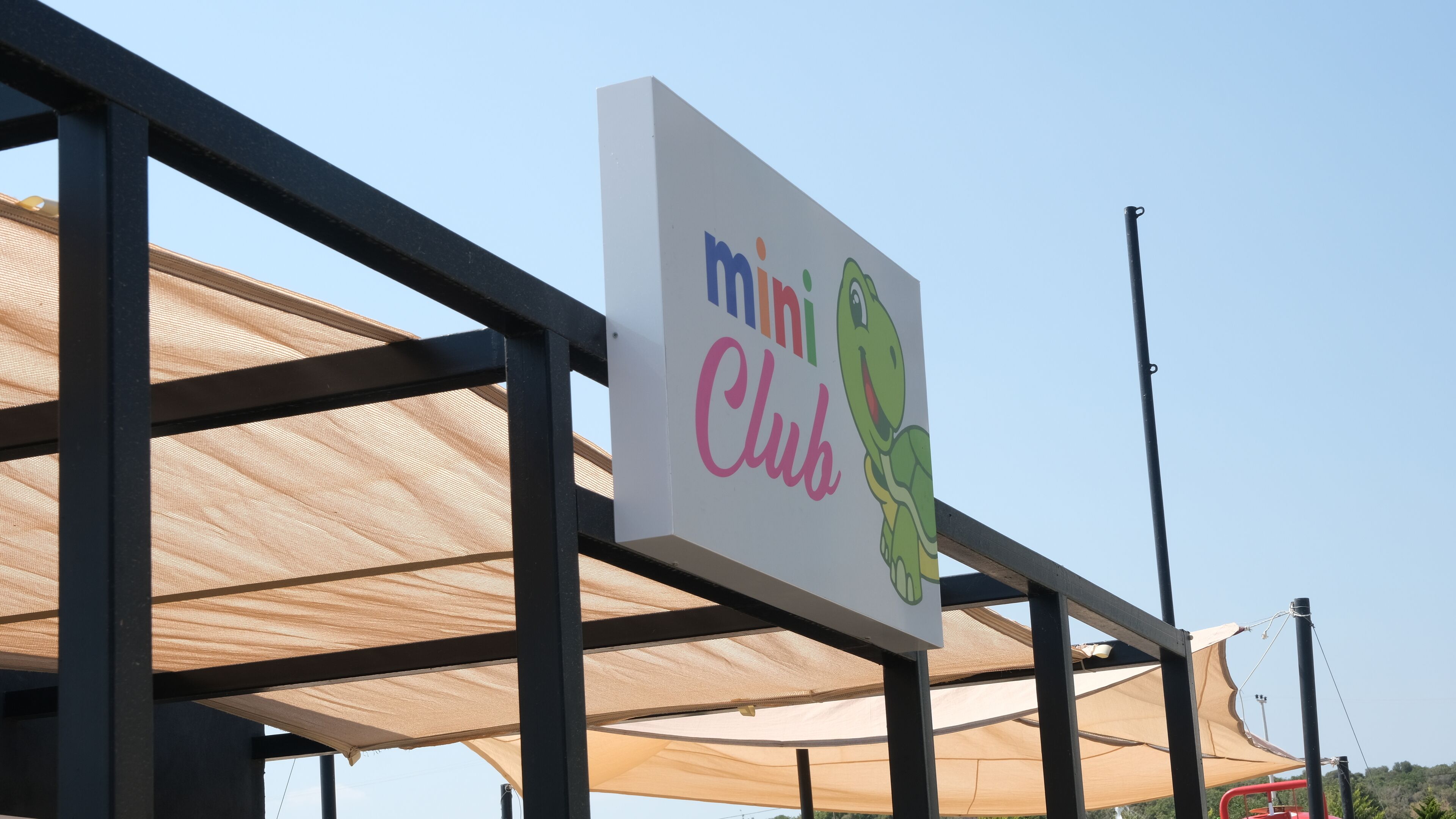 Une enseigne pour un « mini-club », avec un personnage de dessin animé.
