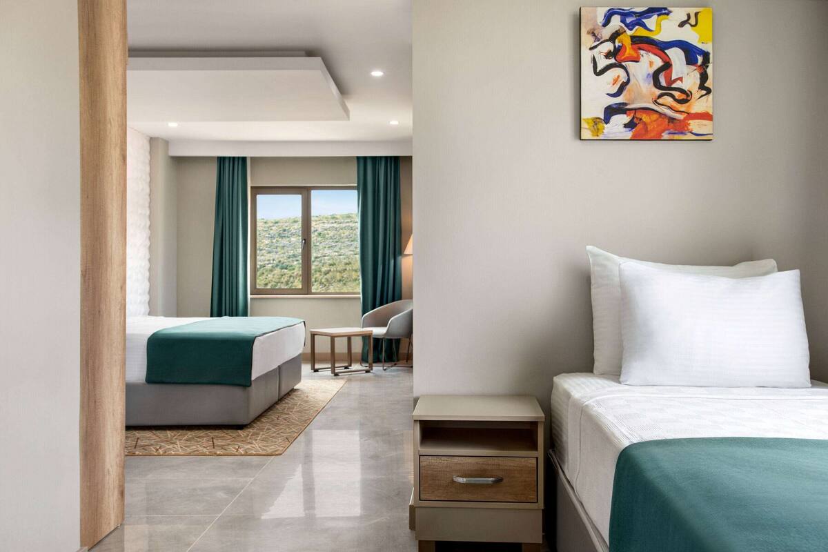 Ein Hotelzimmer mit Bett, Schreibtisch, Stuhl und Blick ins Freie.